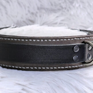 A grey leather collar with black lining and black strap, with white contrast stitching and gunmetal hardware.